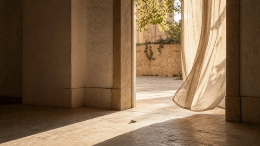 Warm sunlight crossing a stone doorway with a linen curtain, symbolizing returning to journaling after a pause.